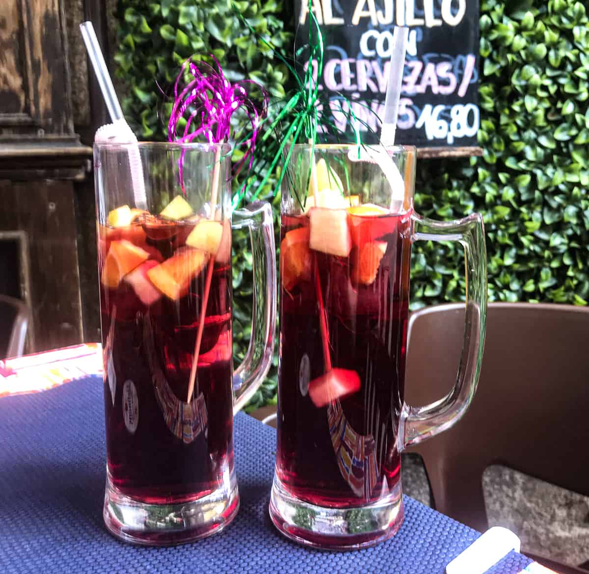 2 large glasses of red sangria on a patio table