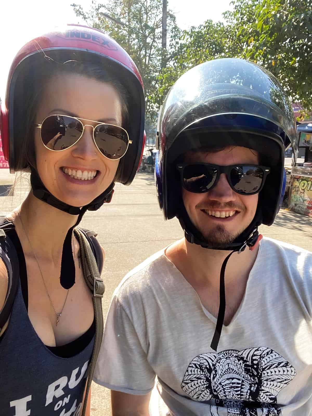 A husband and wife on a motorcycle in Thailand