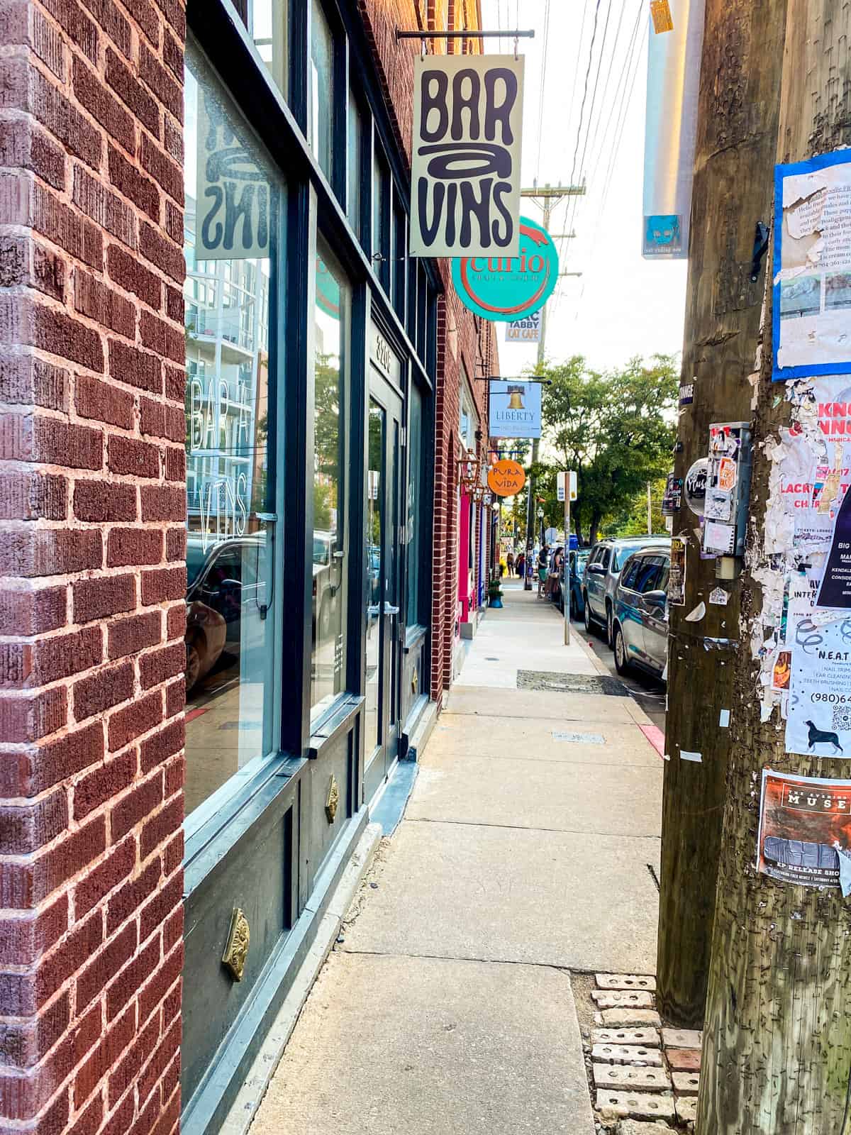 A street in the NODA district in Charlotte, NC with brick buildings and a wine bar.