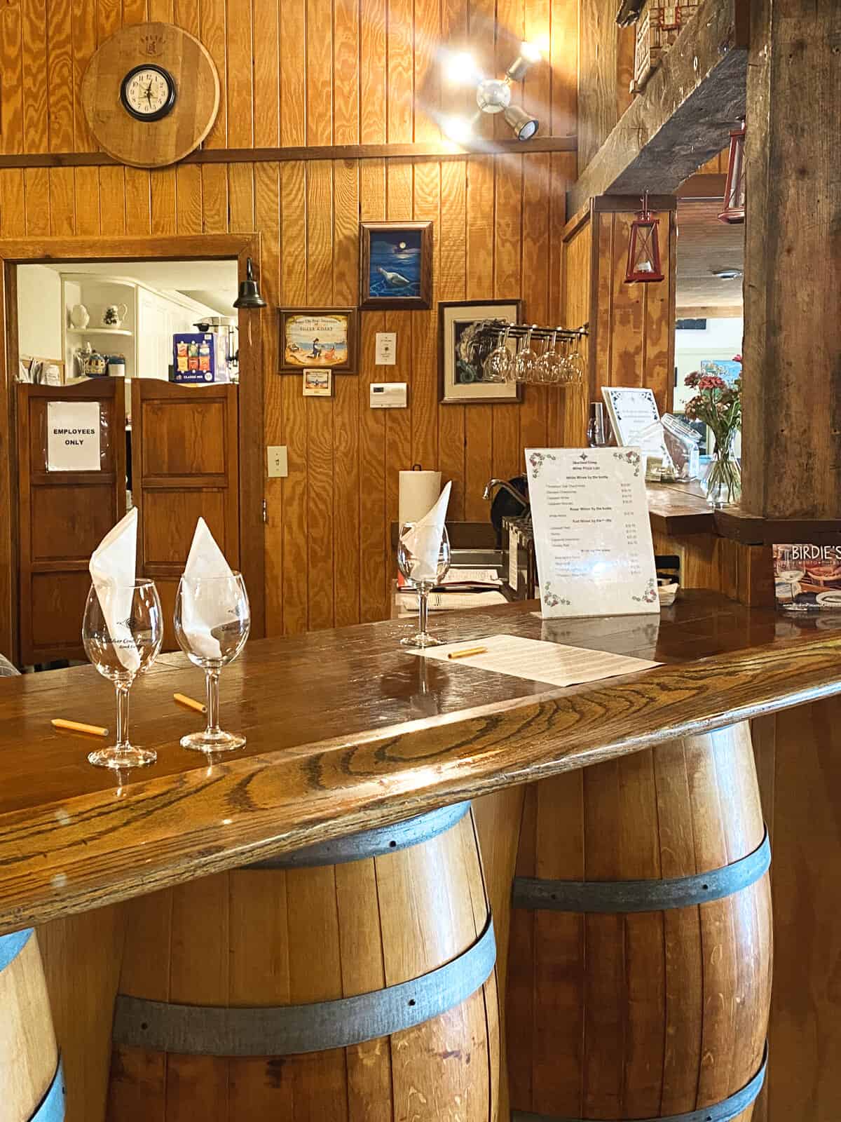 Brown barrels and a counter with wine glasses at the Silver Coast Winery at North Carolina