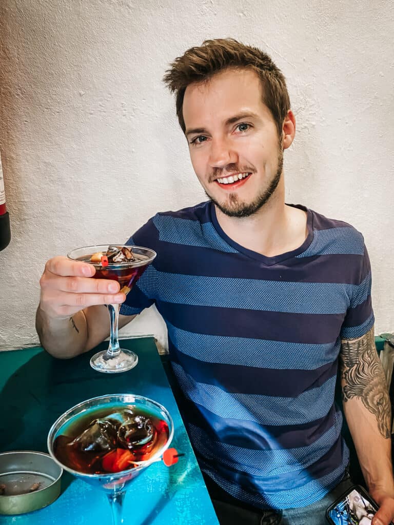 A man sitting at a table holding a glass of Spanish Vermouth