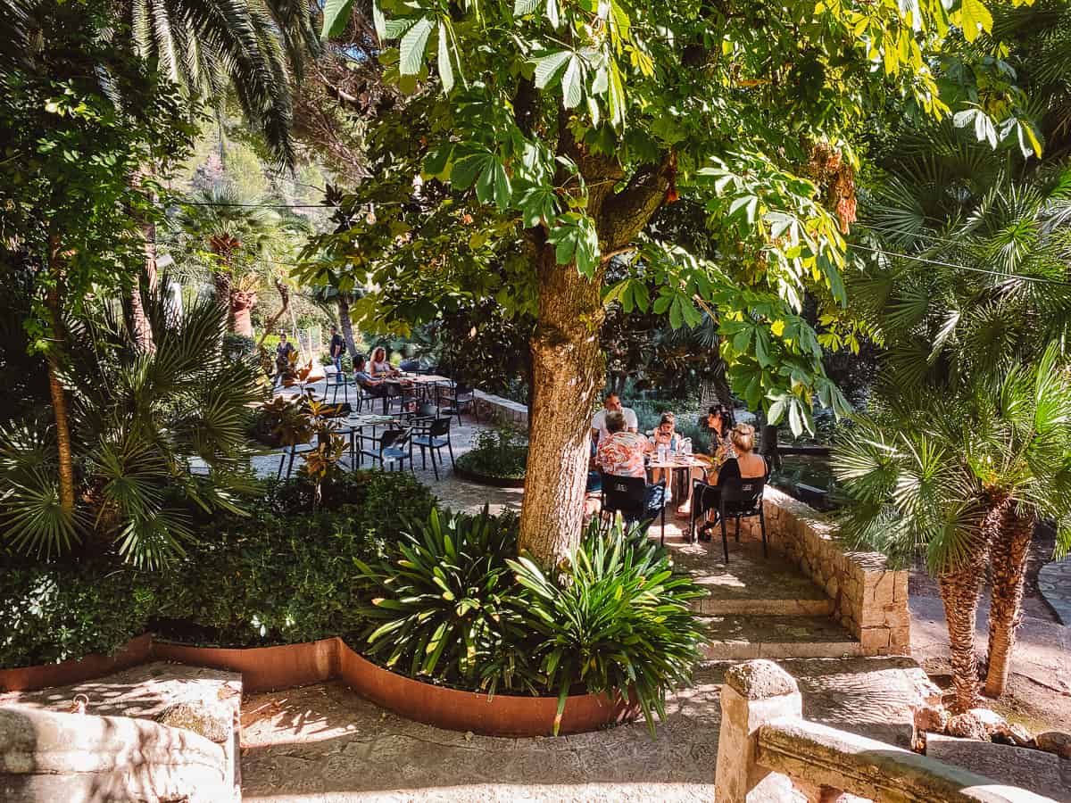 People eating at a restaurant set in a grove of palm trees