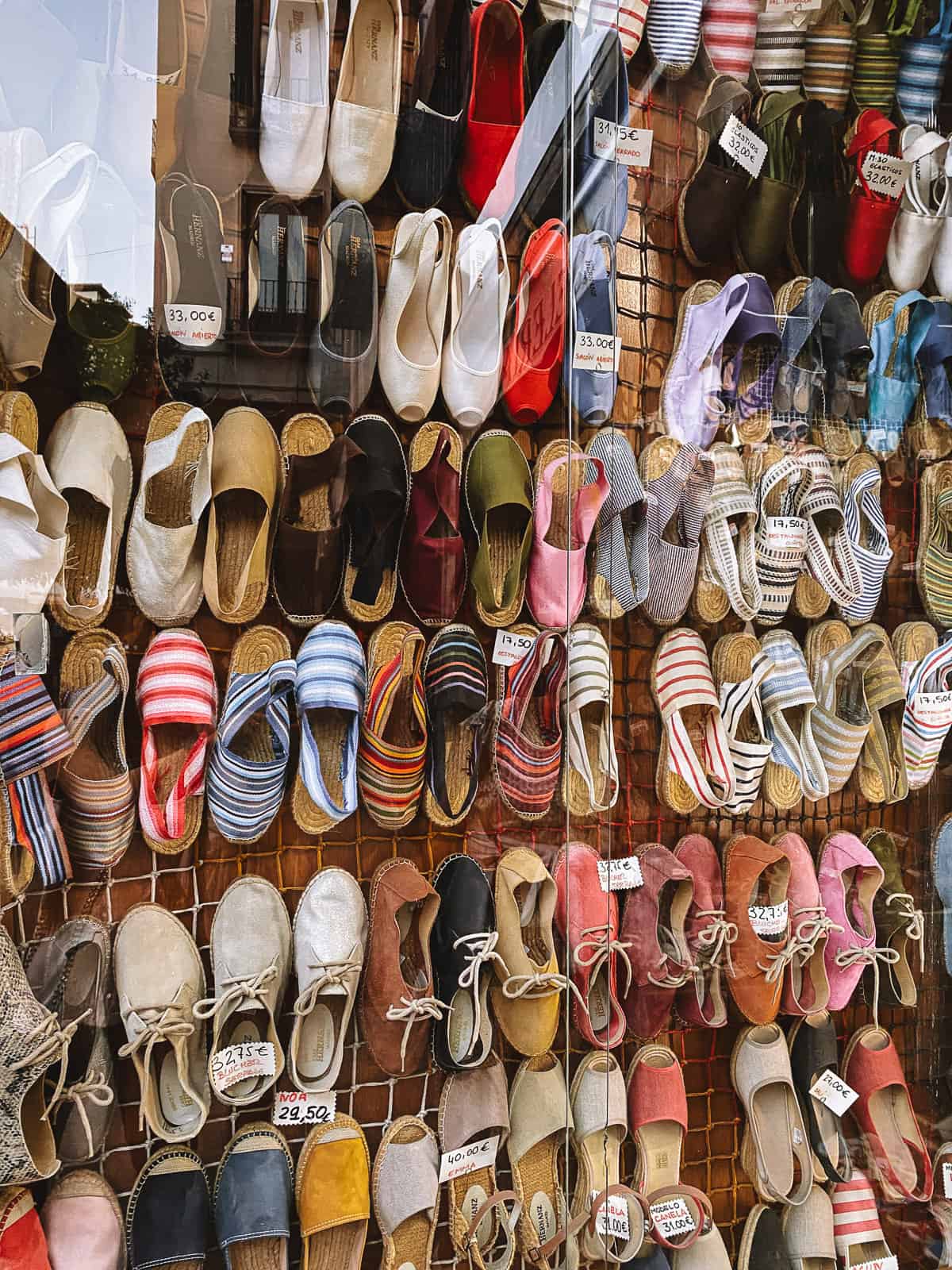 Colorful espadrille shoes hanging in a window