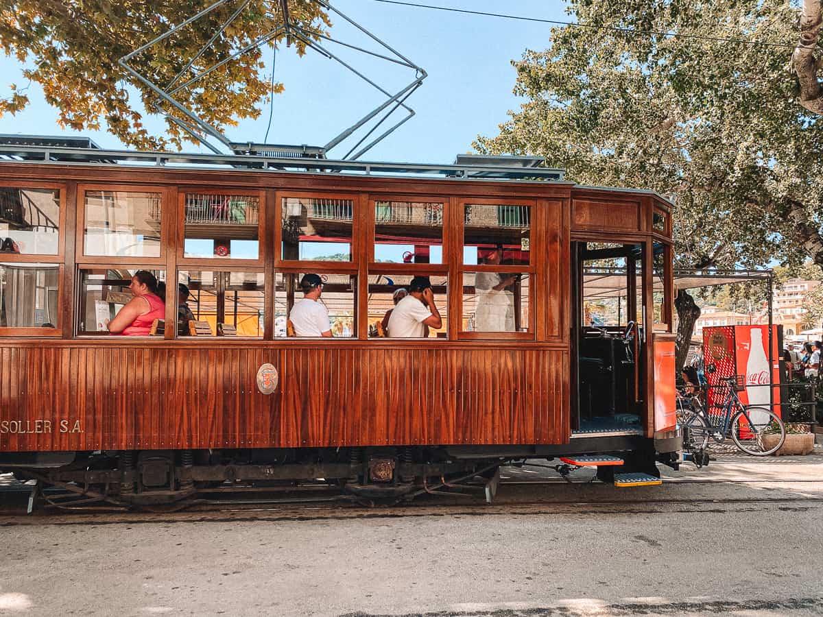 an antique train with people sitting on it