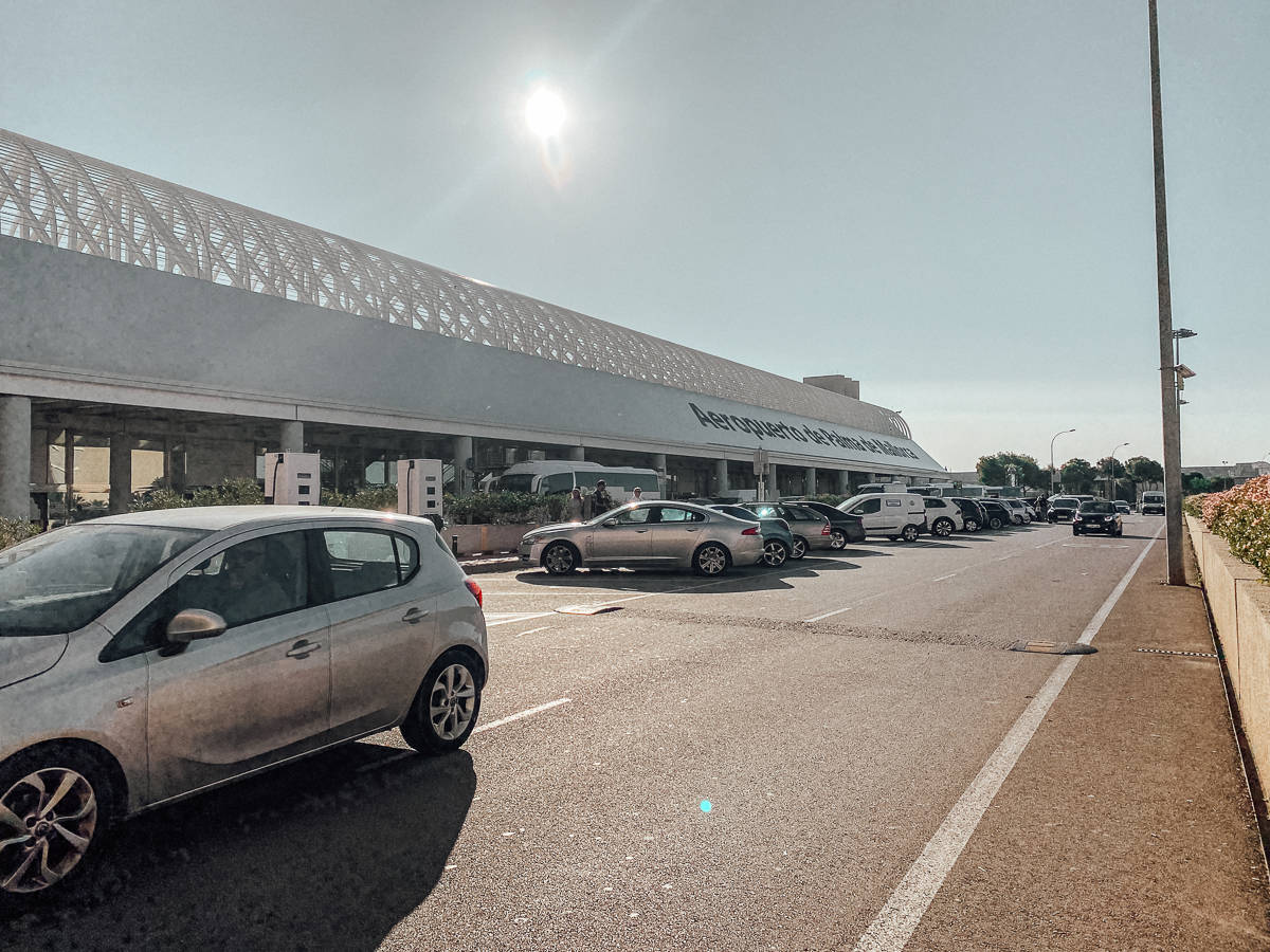 The outside of the airport in Palma de mallorca with cars in front of it