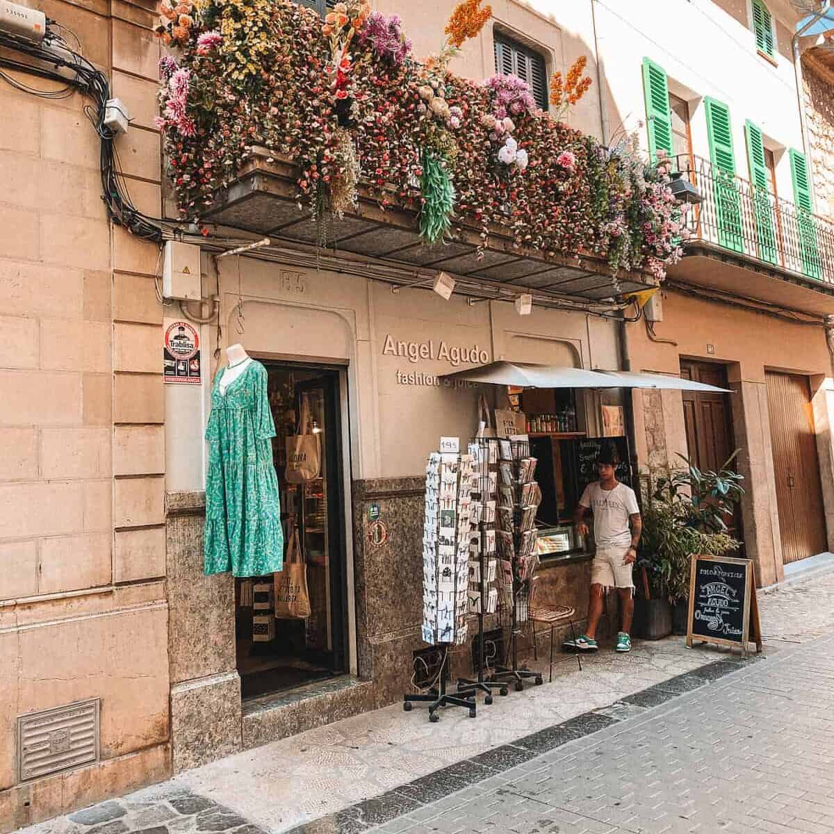a brown storefront with a patio that has hanging flowers on it