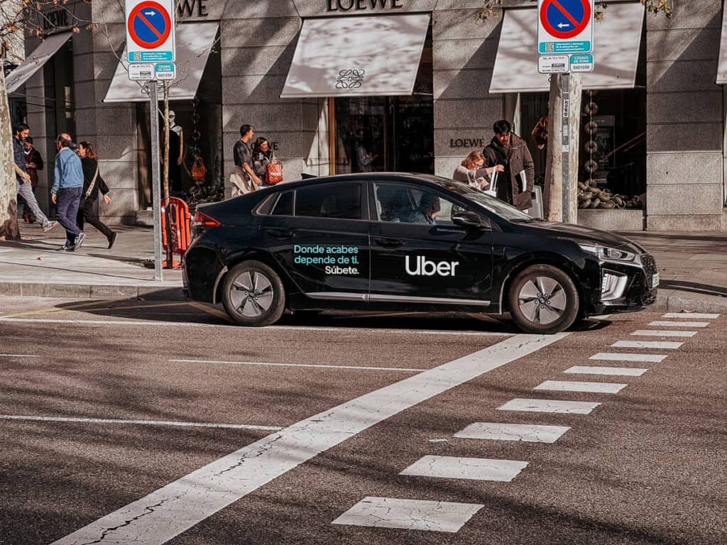 a black uber car driving down a street in Madrid