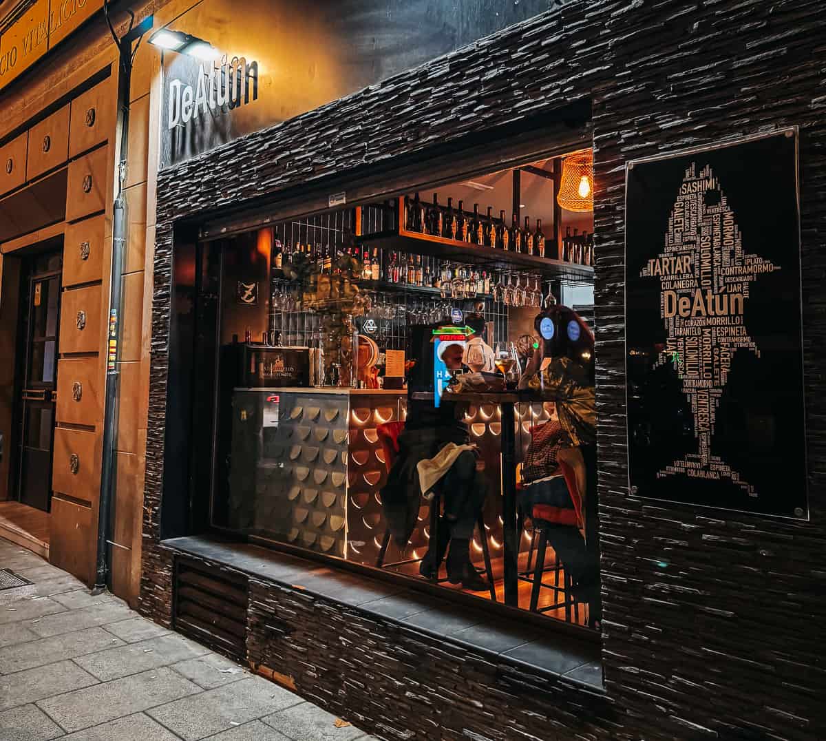 A stylish tapas bar with stone walls and a sign that reads 