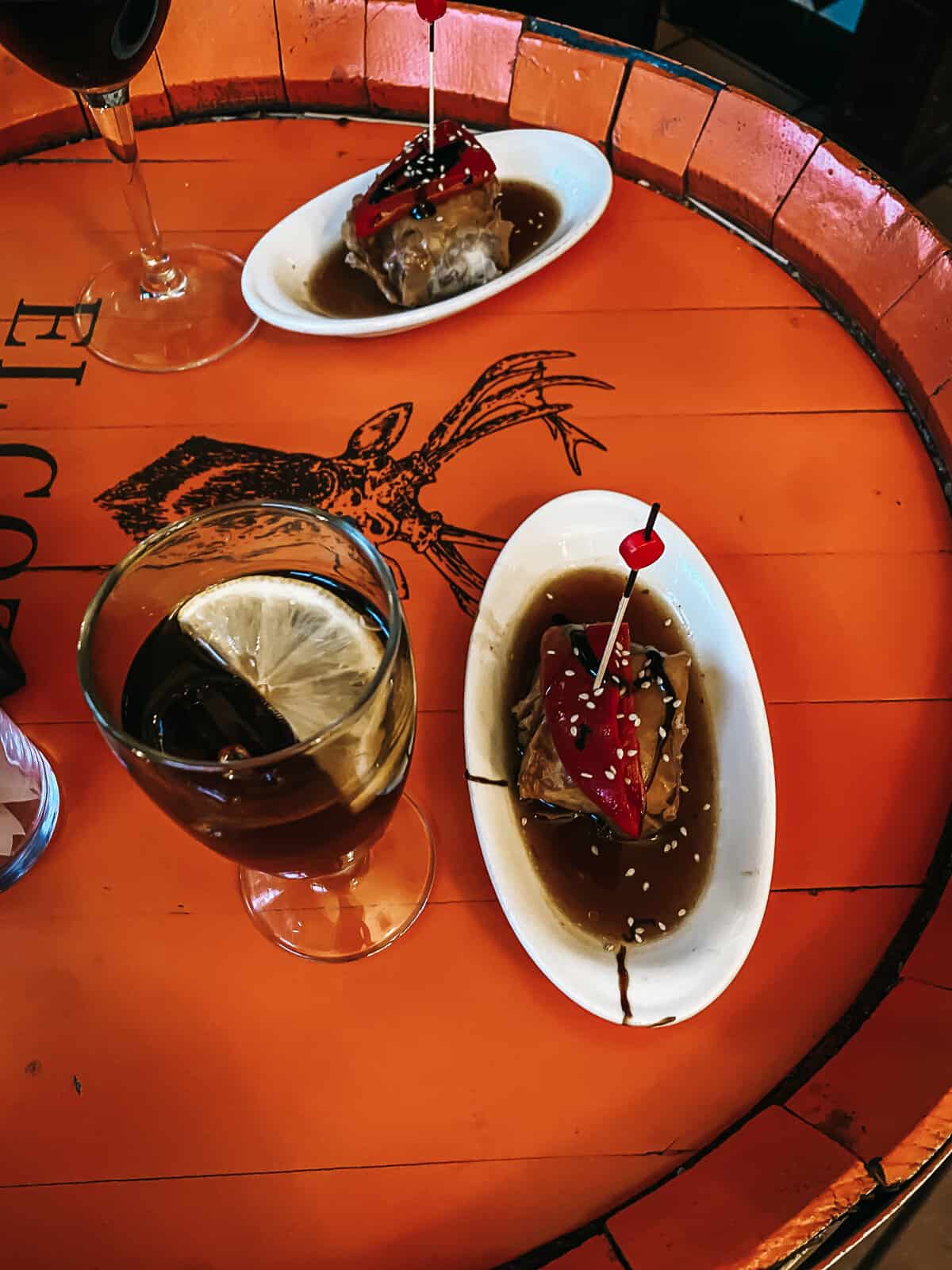 Regalitos de Rabo de Toro from el Anciano rey de los Vinos in Madrid on a table with a glass of vermouth