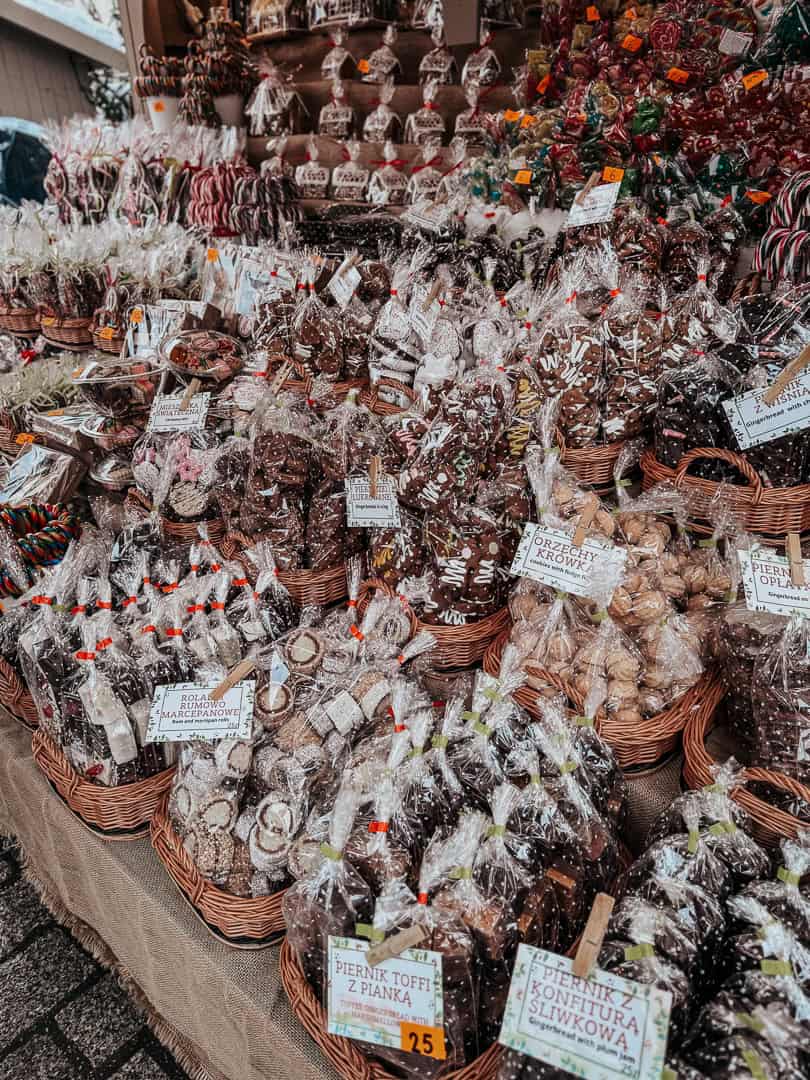 A wide selection of traditional Polish gingerbread in various shapes and sizes, displayed in wicker baskets at a Krakow Christmas market