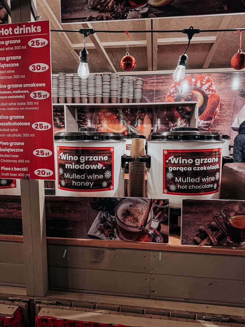 Aromatic mulled wine and hot drink stall, with menu and prices displayed, inviting Christmas market-goers in Krakow.