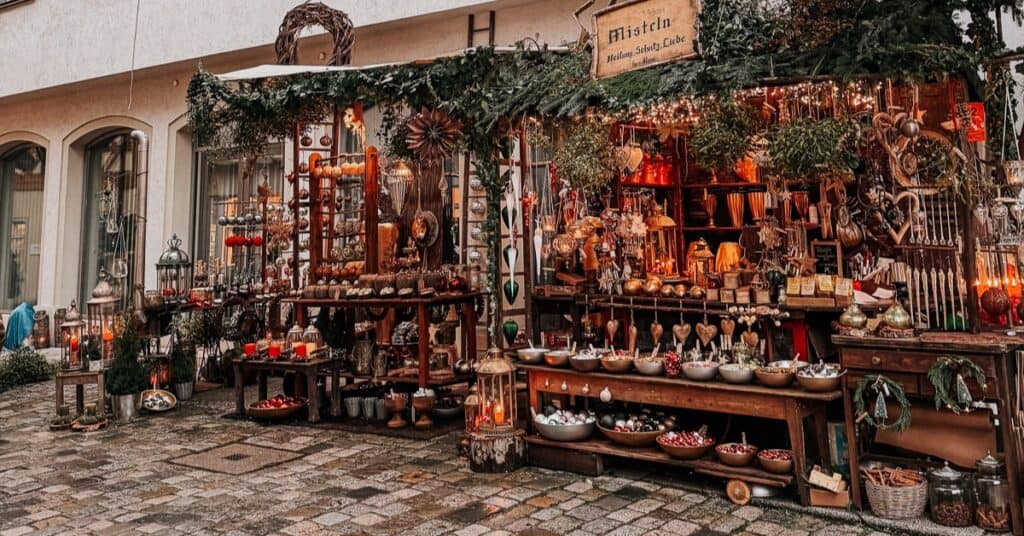 a wooden christmas market stall wrapped with lights and garland