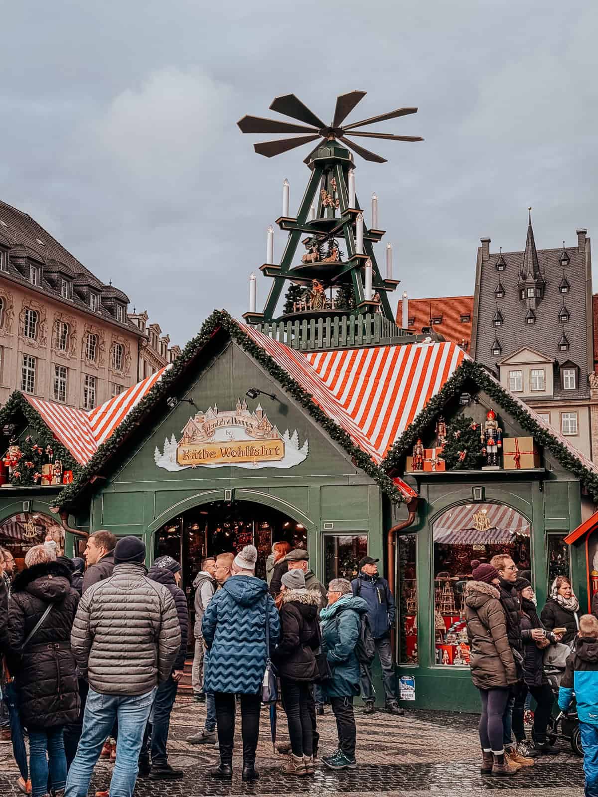 A Kathe Wolfhart stall in a Chrismas market in Europe decorated in candy cane stripes with green siding