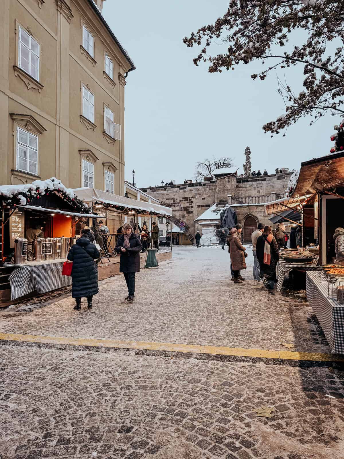 a small and empty Christmas market in Prague with a few wooden stalls