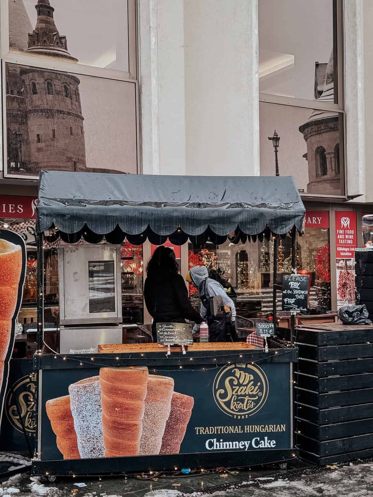 a small blue stall in Budapest selling chimney cakes