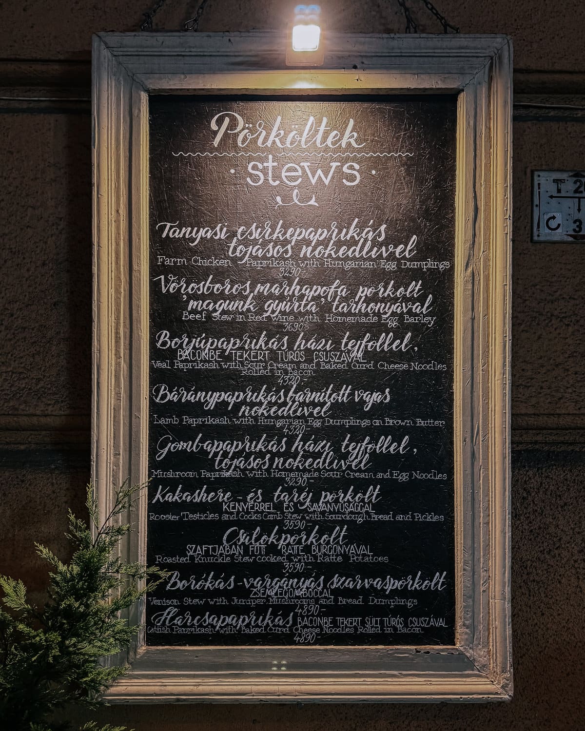 A chalkboard menu listing various stews, with dishes like 