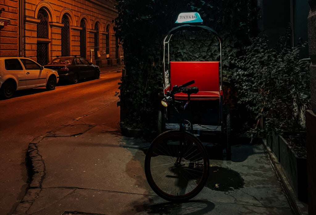 A rickshaw with a sign reading 