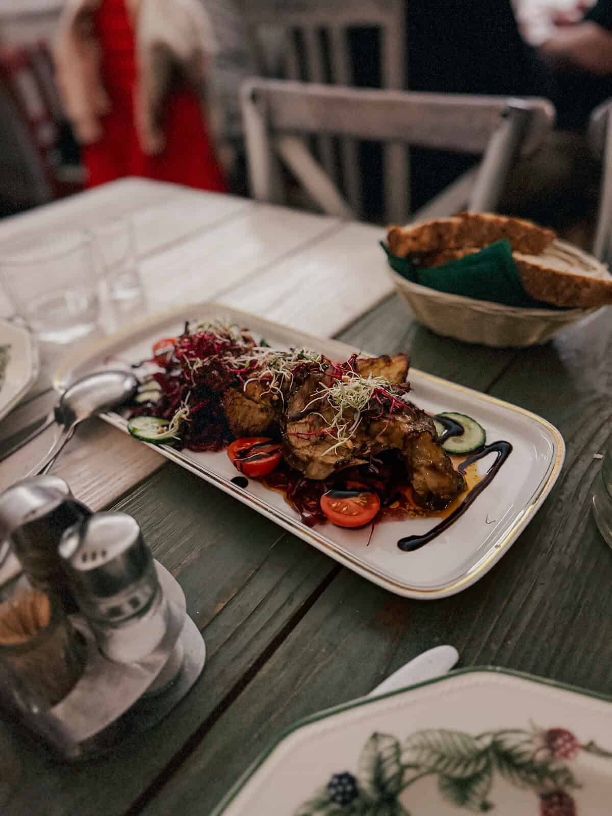 a plate piled high with pork chops on a white farm table