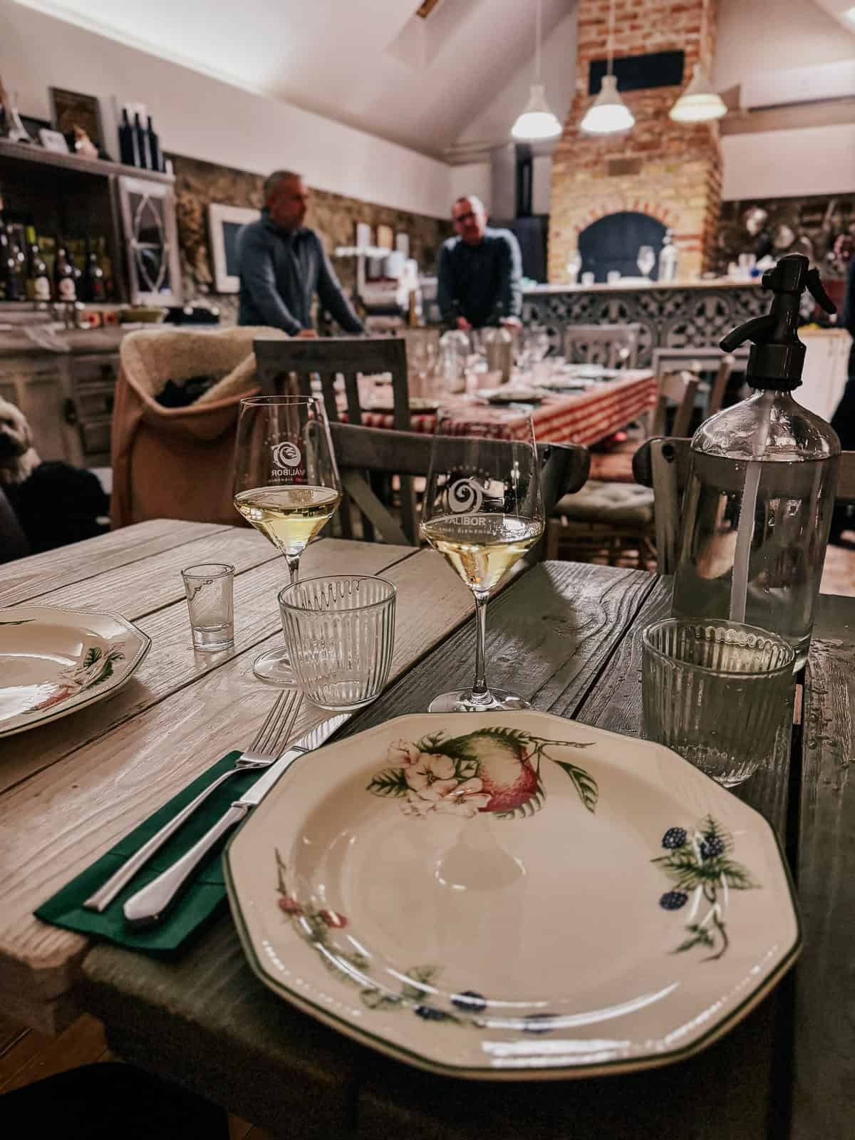 an antique plate and glass of white wine in a farm house inspired wine tasting room