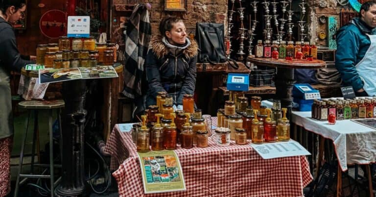 A woman selling handmade jams at an eclectic farmers market in a Budapest ruin bar