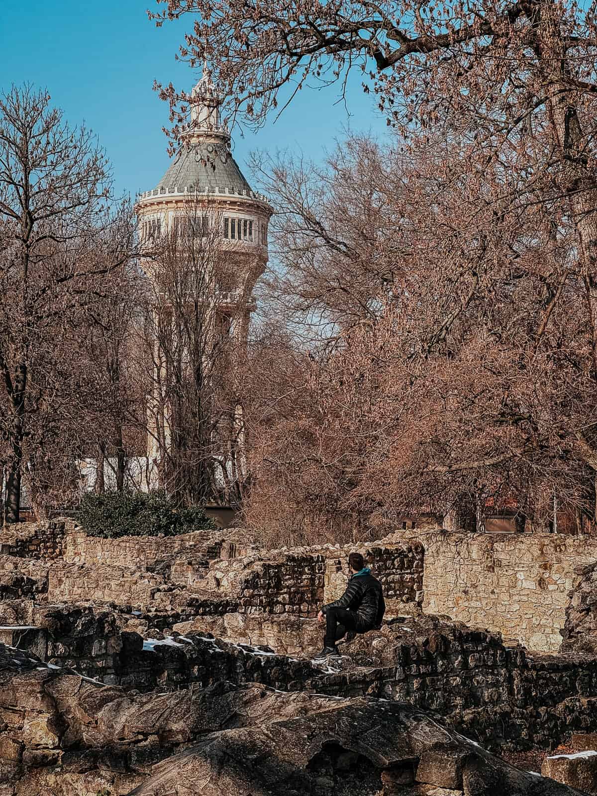 Stone ruins with scattered snow and bare trees under a clear sky on Margaret Island.