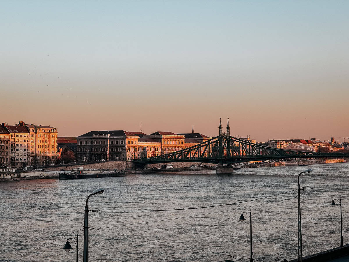 Image showing the Liberty Bridge and buildings along the Danube River at sunset in Budapest.