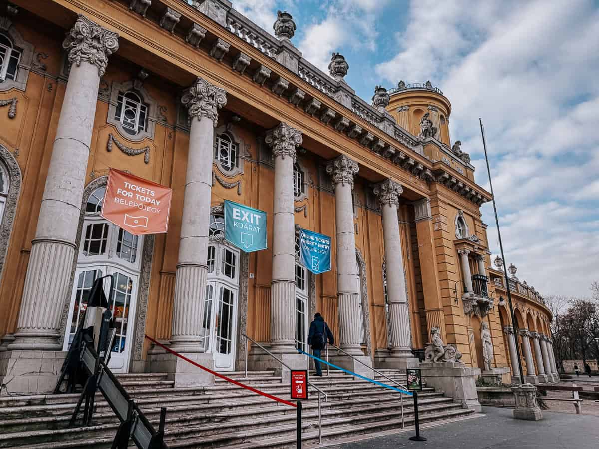 The grand entrance with tall columns, ornate details, and banners for tickets and exit, providing a welcoming and majestic entry point