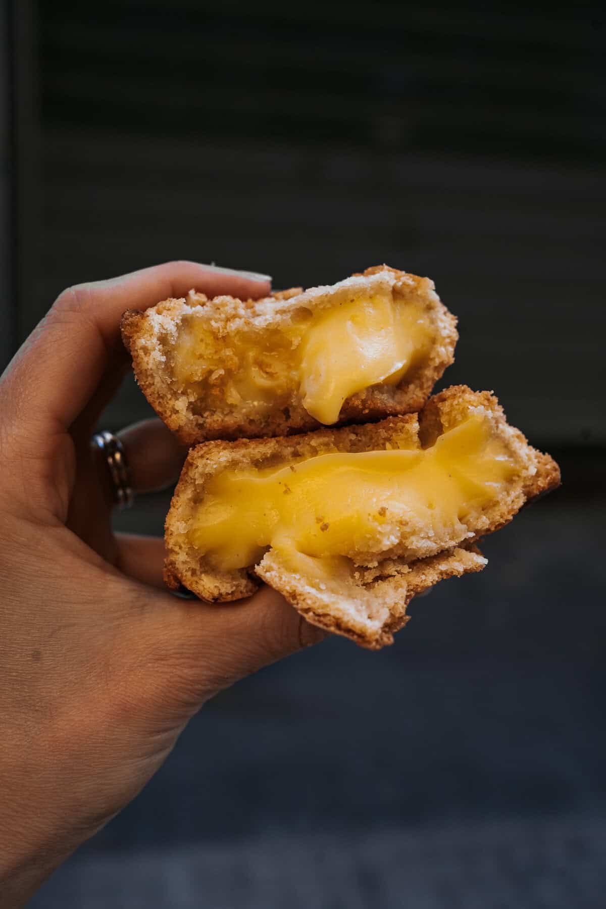 A close-up of a traditional pasticciotto pastry, cut in half to reveal its warm, creamy custard filling, a beloved treat in Lecce.