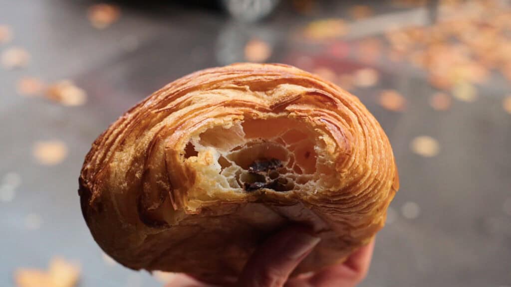 Buttery pain au chocolat in Lyon with visible flaky layers and melted chocolate in the center