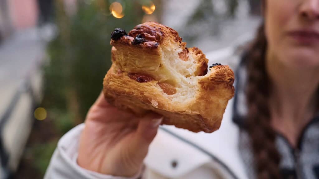 Bitten raisin roll pastry from Lyon, revealing soft, buttery layers and a generously filled interior