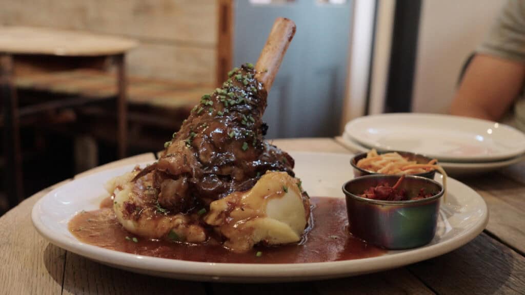 Slow-braised lamb shank with gravy and mashed potatoes at a traditional Edinburgh restaurant