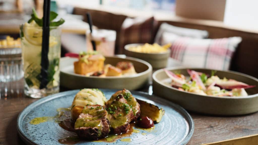 Modern Scottish lamb dish with mashed potatoes and sides at a Glasgow restaurant